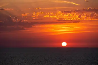 a sunset over the ocean with the sun in the sky at Rose Corse in Santa-Maria-Figaniella