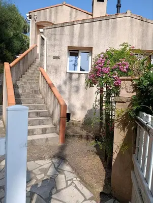 a staircase leading up to a house with pink flowers at Rose Corse in Santa-Maria-Figaniella