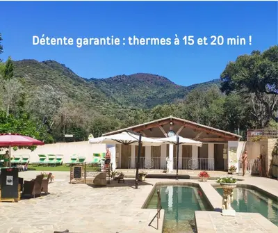 a resort with a pool and mountains in the background at Rose Corse in Santa-Maria-Figaniella
