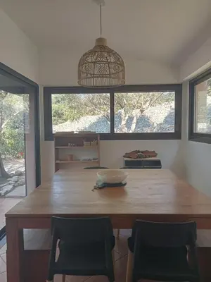 a dining room with a large wooden table and chairs at La Carpa in Bonifacio