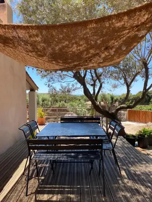 a table and chairs on a deck with a tree at La Carpa in Bonifacio