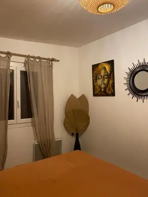 a bedroom with a bed with a fan and a mirror at La Carpa in Bonifacio