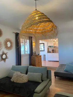 a living room with a couch and a large chandelier at La Carpa in Bonifacio