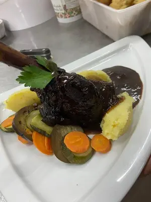 a plate of food with a piece of meat and vegetables at Acquella in Cauro