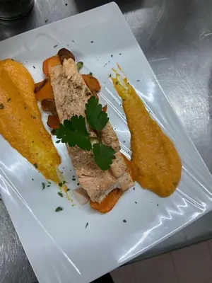 a white plate with a piece of meat and a pickle at Acquella in Cauro