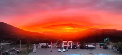 a sunset with a group of chairs and umbrellas at Acquella in Cauro