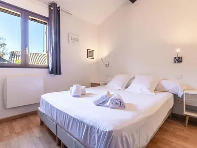 a bedroom with a large white bed with towels on it at Holiday Home Casa Germaine by Interhome in Porto-Vecchio
