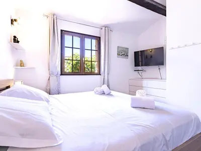 a white bedroom with a large white bed and a window at Holiday Home Casa Germaine by Interhome in Porto-Vecchio