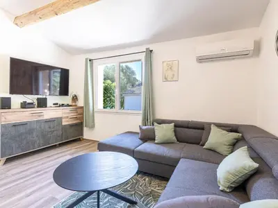 a living room with a couch and a tv and a table at Holiday Home Casa Germaine by Interhome in Porto-Vecchio