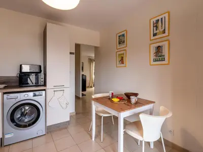 a kitchen with a table and a washing machine at Holiday Home Agula Marina by Interhome in Moriani Plage