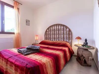a bedroom with a large bed with a red blanket at Holiday Home Agula Marina by Interhome in Moriani Plage