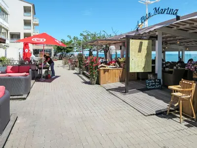a woman standing in front of a market with an umbrella at Holiday Home Agula Marina by Interhome in Moriani Plage