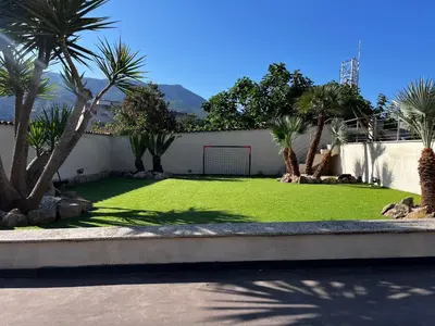 a yard with palm trees and a soccer goal at Résidence COMAEM in Sarrola-Carcopino