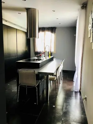 a kitchen with a long table with chairs and a sink at Résidence COMAEM in Sarrola-Carcopino