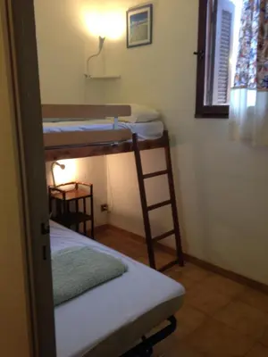a room with two bunk beds and a lamp at Residence ELLADA 1 in Cargèse