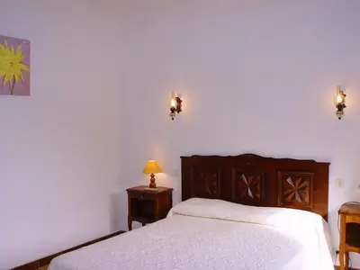 a bedroom with a bed and two lights on the wall at Residence ELLADA 1 in Cargèse