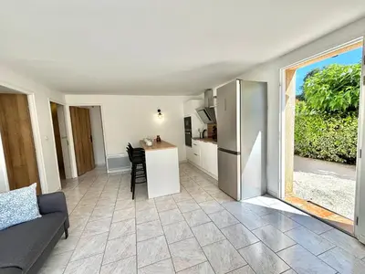 a living room with a couch and a kitchen at Appartement avec piscine privée Porticcio in Porticcio