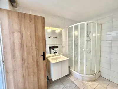 a bathroom with a sink and a glass shower at Appartement avec piscine privée Porticcio in Porticcio