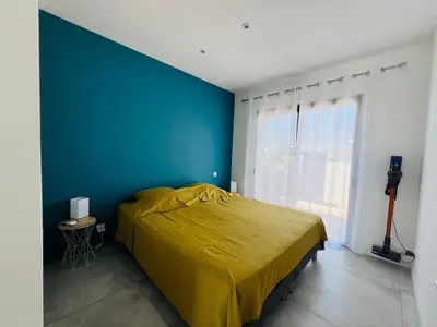 a bedroom with a yellow bed and a blue wall at Villa KAÏS in Lecci