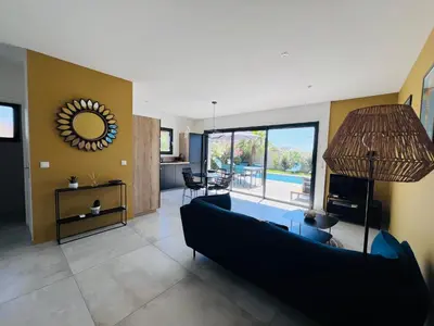 a living room with a black couch and a mirror at Villa KAÏS in Lecci