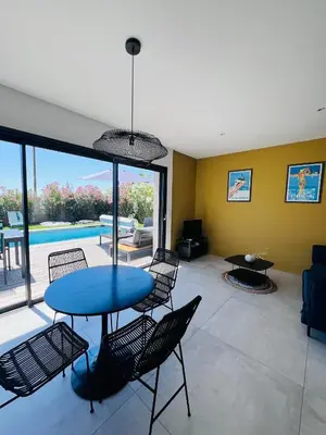 a living room with a blue table and chairs at Villa KAÏS in Lecci