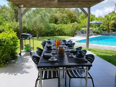 a table with cups and bowls on it next to a pool at Villa Katiris in Porto-Vecchio