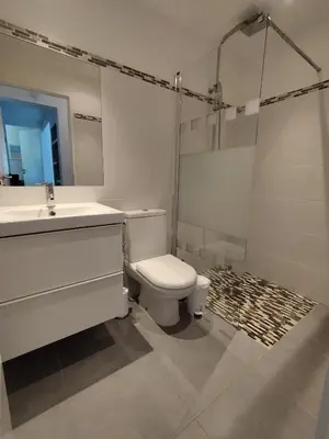 a white bathroom with a toilet and a sink at Villa Katiris in Porto-Vecchio