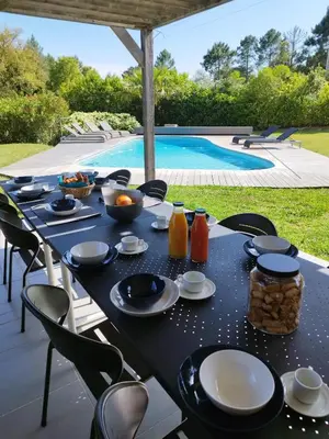 a table with food on it next to a swimming pool at Villa Katiris in Porto-Vecchio