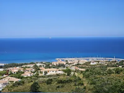 a town on a hill with the ocean in the background at LABELLE- Vue mer panoramique - Piscine privée - Clim -WIFI in Sari Solenzara