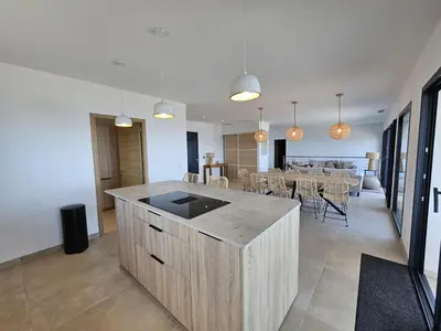 a kitchen and dining room with a table and chairs at LABELLE- Vue mer panoramique - Piscine privée - Clim -WIFI in Sari Solenzara