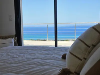 a bedroom with a bed with a view of the ocean at LABELLE- Vue mer panoramique - Piscine privée - Clim -WIFI in Sari Solenzara