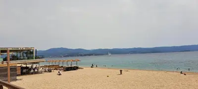 a beach with a pier and people on the water at Charmant studio neuf Ajaccio Casone - Trottel in Ajaccio