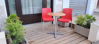 a table and two red chairs on a porch at Charmant studio neuf Ajaccio Casone - Trottel in Ajaccio