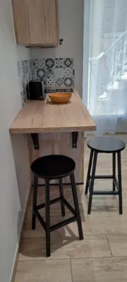 a kitchen with a wooden counter with two stools at Charmant studio neuf Ajaccio Casone - Trottel in Ajaccio