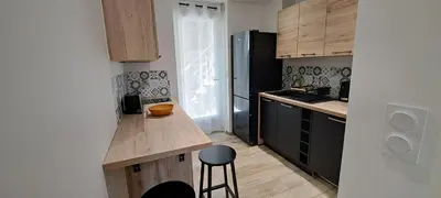 a small kitchen with a counter and a stool at Charmant studio neuf Ajaccio Casone - Trottel in Ajaccio