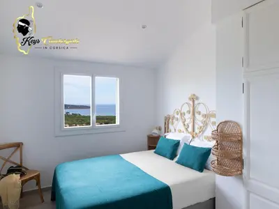 a white bedroom with a bed and a window at Villa Ficaja 10 pers JACUZZI vue MER PINARELLO in Zonza