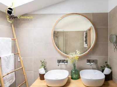 a bathroom with two sinks and a mirror at Villa Ficaja 10 pers JACUZZI vue MER PINARELLO in Zonza