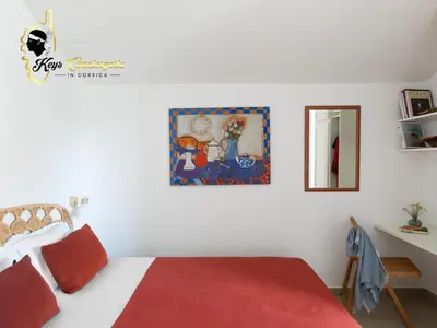 a bedroom with a bed and a painting on the wall at Villa Ficaja 10 pers JACUZZI vue MER PINARELLO in Zonza
