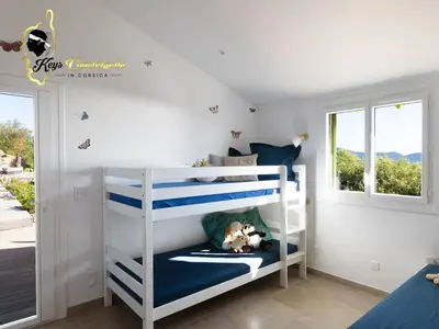 a childs bedroom with two bunk beds and a window at Villa Ficaja 10 pers JACUZZI vue MER PINARELLO in Zonza