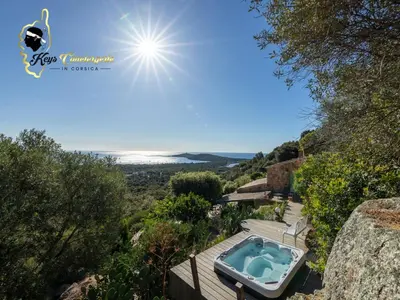 a hot tub on a deck with a view of the ocean at Villa Ficaja 10 pers JACUZZI vue MER PINARELLO in Zonza