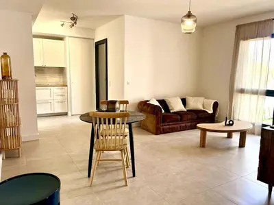 a living room with a couch and a table at Appartement neuf centre-ville in Porto-Vecchio