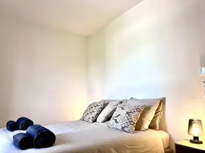 a bedroom with a bed with blue pillows on it at Appartement neuf centre-ville in Porto-Vecchio