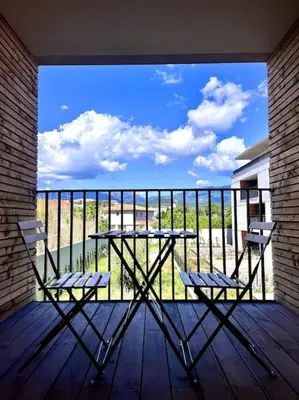 a table and two chairs on a balcony with a view at Appartement neuf centre-ville in Porto-Vecchio
