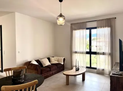 a living room with a couch and a table at Appartement neuf centre-ville in Porto-Vecchio