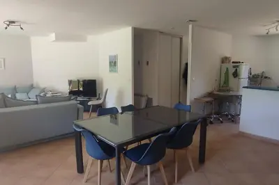 a living room with a table and blue chairs at Villa Callochiusa avec piscine 15mn Bonifacio in Figari