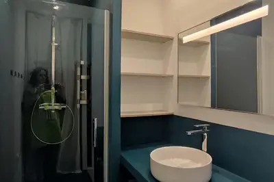 a person taking a picture of a bathroom with a sink at Villa Callochiusa avec piscine 15mn Bonifacio in Figari
