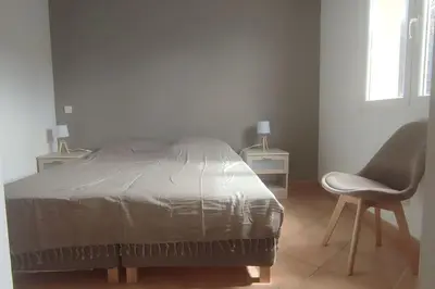 a bedroom with a bed and a chair and a window at Villa Callochiusa avec piscine 15mn Bonifacio in Figari