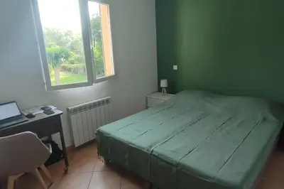 a bedroom with a bed and a desk and a window at Villa Callochiusa avec piscine 15mn Bonifacio in Figari