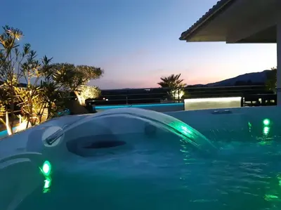 a swimming pool with green lights in the water at Appartement dernier étage avec spa privatif sur grande terrasse in Porto-Vecchio