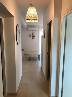 a hallway with a room with a table and a light at Appt T4 Accès Plage, piscine privée, clim N3-4 in Linguizzetta